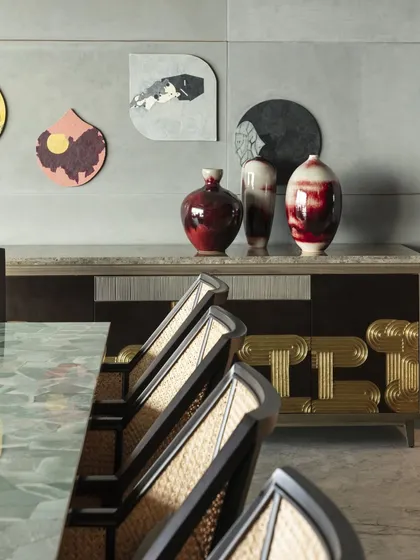 The custom sideboard in the Kolkata dining room, featuring hammered brass and bronze Thathera work. This piece is paired with vibrant red ceramic vases to create a striking focal point.