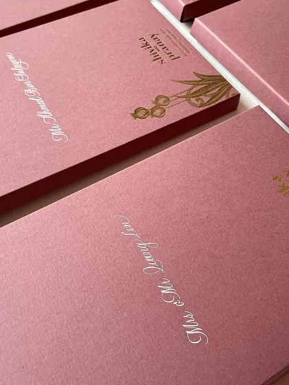 Another angle of the white-on-pink calligraphy. Consistency in script and layout is key when working on a large set of wedding invitations.