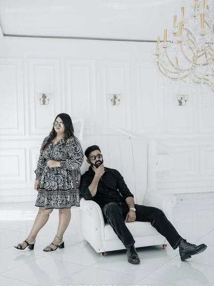 A playful yet stylish pose in the all-white room, showcasing the couple's personality.