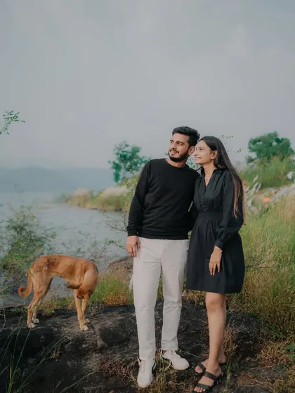 A candid moment as the couple looks out over the lake. The unexpected appearance of a dog adds a touch of spontaneous life to this beautifully composed, story-driven shot.