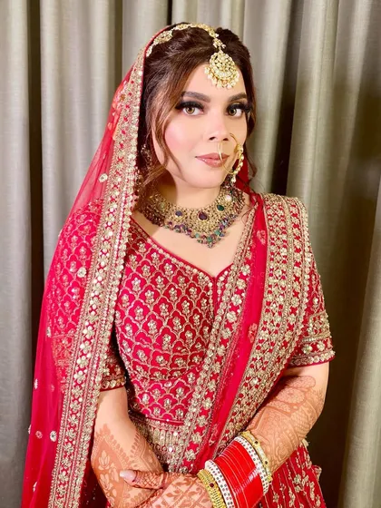A close-up of the gorgeous Lavanya. Her bridal makeup features a soft smokey eye and a neutral lip, allowing her stunning red outfit and jewelry to take center stage.