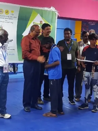 A proud moment as one of our boxers receives his medal from an official at the Mini Olympics. This is the culmination of months of dedicated training.