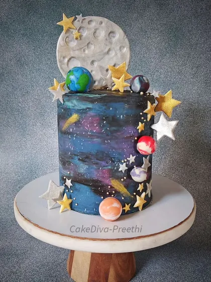 I love how this galaxy cake turned out. It’s a double-barrel cake, standing almost 12 inches tall, with a decadent chocolate sponge inside. I created the galaxy effect using multi-colored white chocolate ganache, complete with a fondant moon and edible stars.