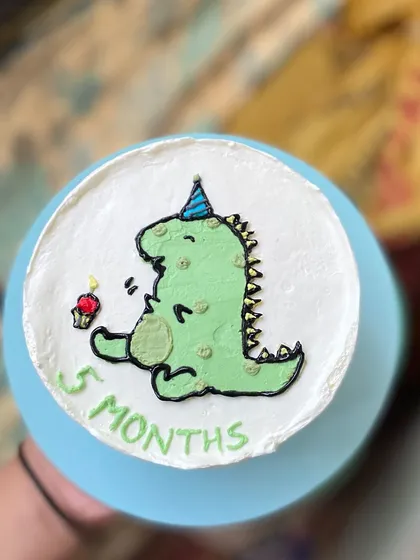A clean top-down shot of the dinosaur cake before the smash.