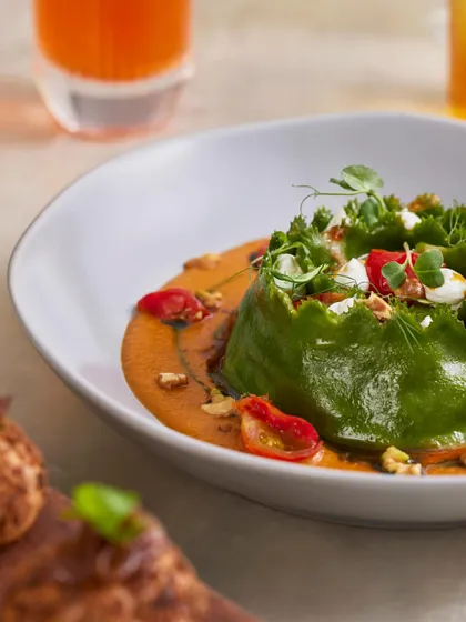 The textures of our Crown Raviolo. You can see the creamy goat's cheese, juicy cherry tomatoes, and crunchy walnuts that make every bite a new experience.