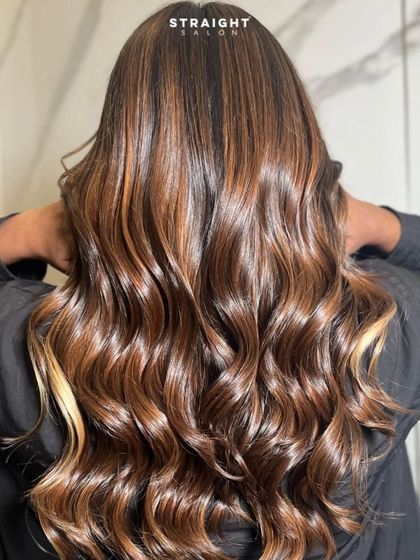 A back view of this multi-tonal balayage, styled into glamorous waves.