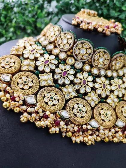 A detailed shot of the necklace, showing the mix of different kundan patterns and colored stones that give it a rich, textured look.