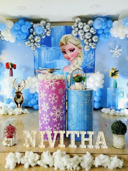 Let it go! I bring the enchanting world of Frozen to life with this icy blue and silver decoration. The setup includes a shimmering backdrop, character cutouts of Elsa, and snowflake details to create a winter wonderland.