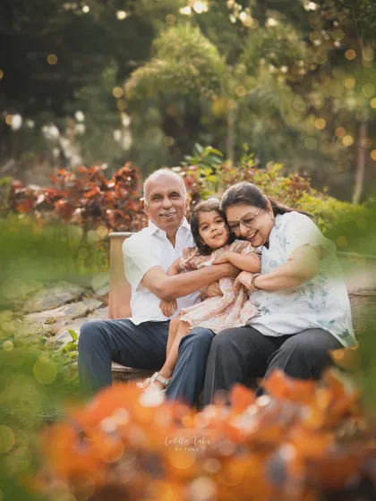 A granddaughter wrapped in a warm hug between her grandparents on a park bench. I focus on capturing these priceless, multi-generational bonds that form the legacy of a family.