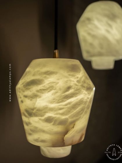These geometric pendants are carved from a single piece of beige marble. Their unique, faceted shape and the soft glow from within make them a subtle yet elegant choice for modern kitchens or bedside lighting.