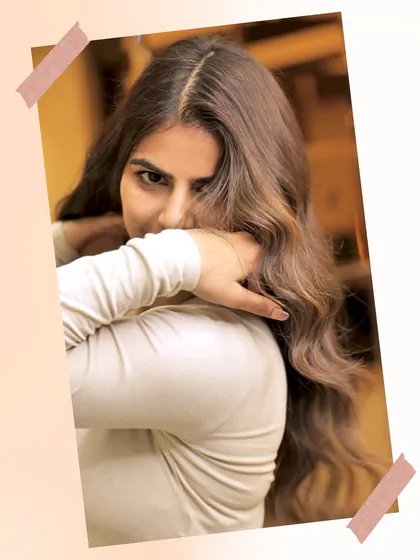 A playful shot of our client enjoying her new, glossy brown hair. The color is rich and vibrant, a testament to our expert coloring techniques.