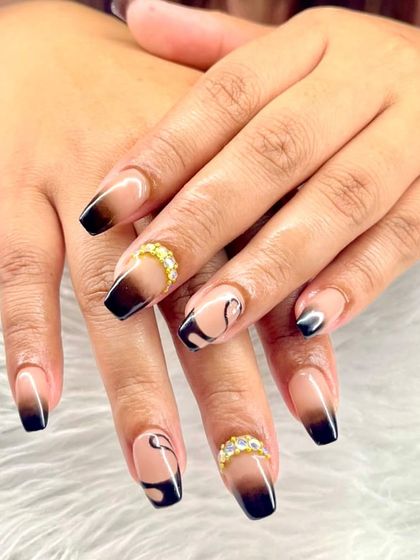 Black ombré plus gold accents equals classy with a side of drama. This set features ombré French tips with abstract swirls and gold crystal bands.