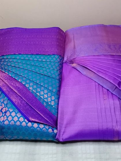 Two beautiful purple sarees, one with a check pattern and one plain. Both are pleated and ready, showcasing the versatility of my service.