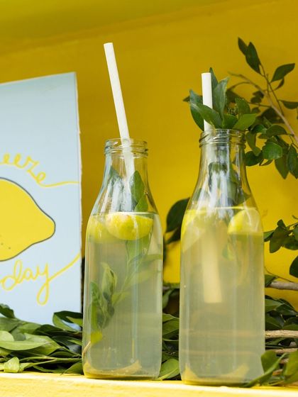 Refreshing lemonade served in glass bottles with fresh mint, a perfect thematic treat for the party.