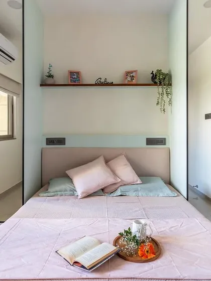 A head-on view showing how the mirrored wardrobes on both sides of the bed make the room feel significantly larger and brighter.