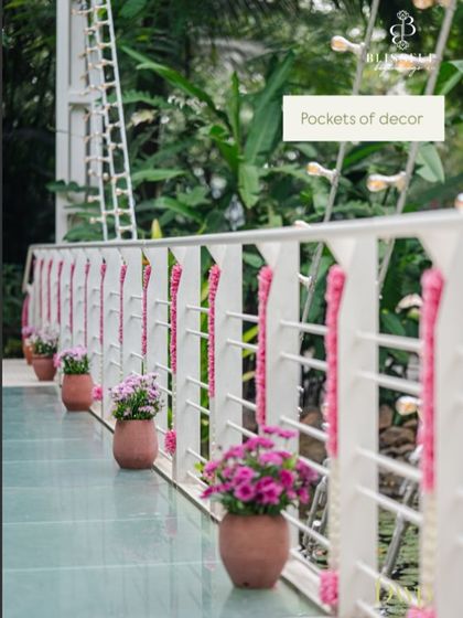 Pockets of decor, like these small potted plants and pink floral garlands, add charm and detail to every corner of the venue. We believe every part of the space should feel special.
