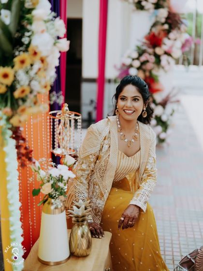 A happy bride-to-be at her carnival-themed Mehendi, surrounded by vibrant decor.
