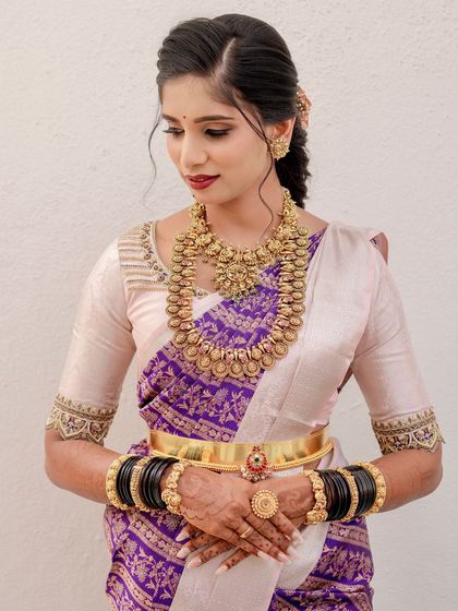 A close-up of the bride, showing the delicate embroidery on her blouse and her beautiful makeup.