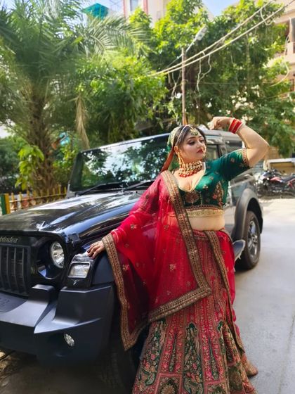 A bride with swag. This client paired our traditional red and green bridal lehenga with a Thar for a truly memorable wedding photo.