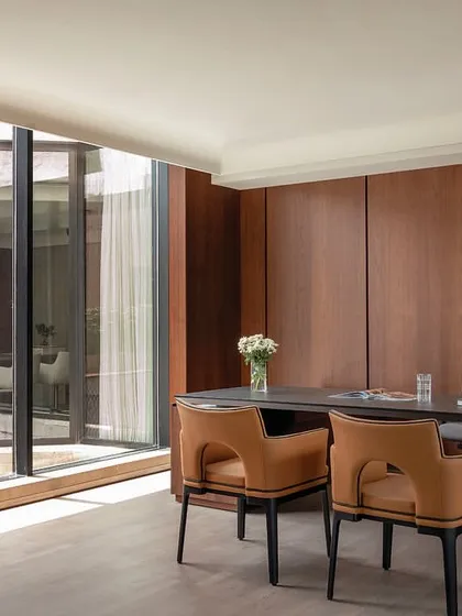 We tailor executive spaces to individual tastes, like this director's cabin in The Layered Office, which offers prime views of a landscaped terrace and features bespoke wood paneling and curated furniture.