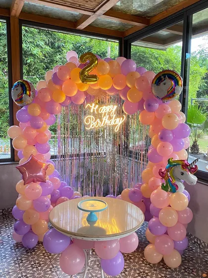A clear view of the unicorn-themed second birthday setup, complete with a cake table.