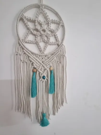 This macrame dreamcatcher is designed to bring serene, artistic energy to your bedroom or living space. The intricate star-like pattern is woven with natural cotton cord and accented with wooden beads and soft tassels.