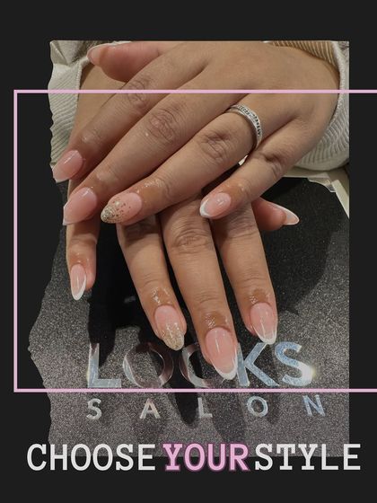 A classic French manicure with a twist. This look features a subtle glitter accent on the ring finger, adding a touch of sparkle to the timeless white-tipped design.