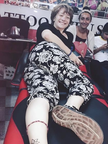 A happy international client showing off her new lotus tattoo.