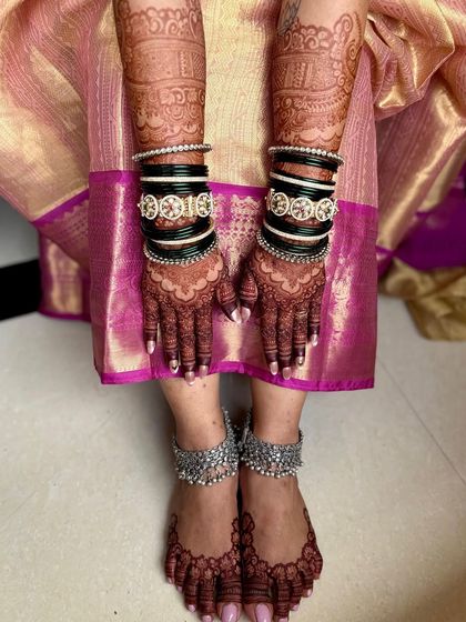 Another view of the matching hands and feet mehendi, adorned with traditional bridal bangles and anklets.