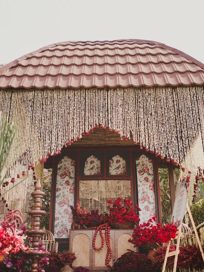 A charming decor element with a curtain of flowers (gajra) framing a small, traditional-style structure.