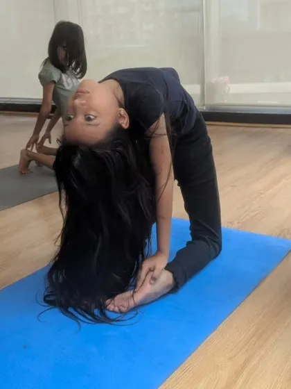 Flexibility is a cornerstone of gymnastics. This student demonstrates a beautiful bridge pose, showcasing the strength and control we help develop through dedicated stretching and conditioning exercises.