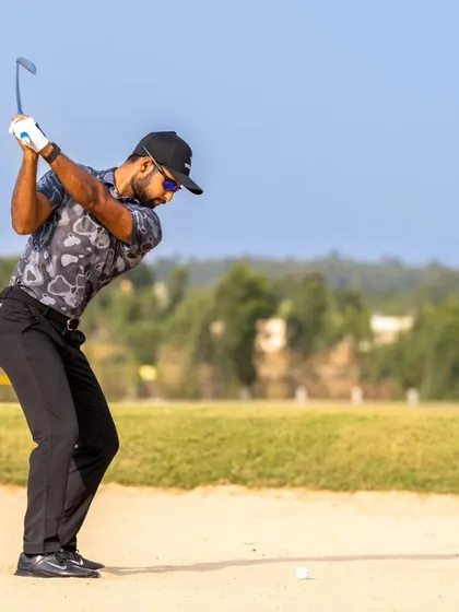 Escaping a bunker requires specific skills. Here, a golfer demonstrates the correct form for a sand shot, a technique we cover in our short game lessons.