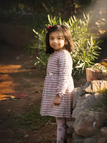 A sweet portrait of a little girl in a park, with the soft afternoon light creating a beautiful glow around her. Outdoor settings offer the most beautiful natural light.