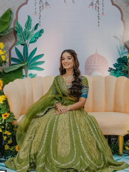 A full-length shot of the bride on her mehendi day, showcasing her beautiful green lehenga.