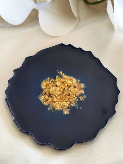 Sometimes, simplicity is the most beautiful. This deep navy blue coaster has a simple cluster of gold flakes in the center, creating a striking contrast.