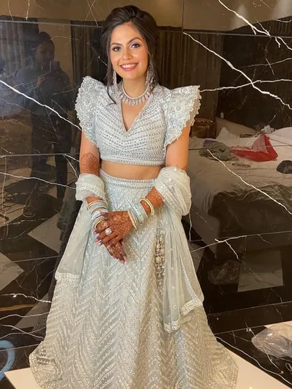 A happy client looking absolutely lovely in our powder blue lehenga with modern ruffled sleeves and silver embroidery. This is a wonderful option for bridesmaids or for an engagement ceremony.
