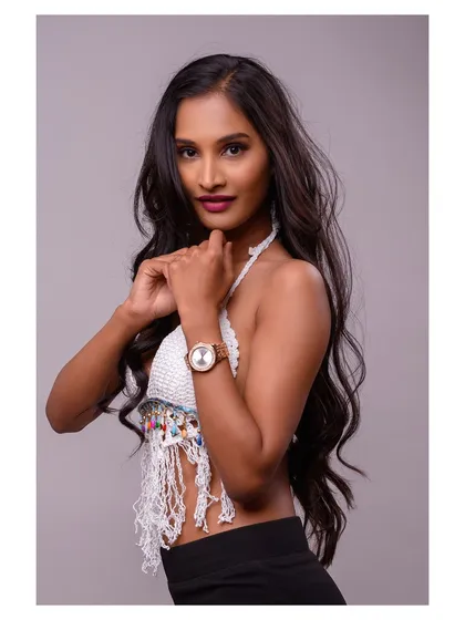 A studio lookbook image for a knitwear brand. The model wears a white crochet halter top, and the clean background keeps the focus on the product's texture and details.