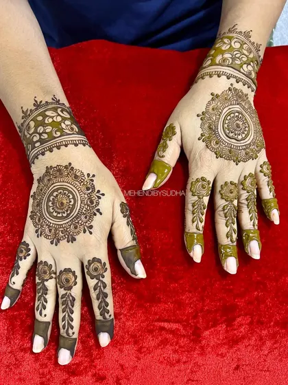 A classic mandala design on the palm, surrounded by simple floral details on the fingers and a beautiful cuff on the wrist.