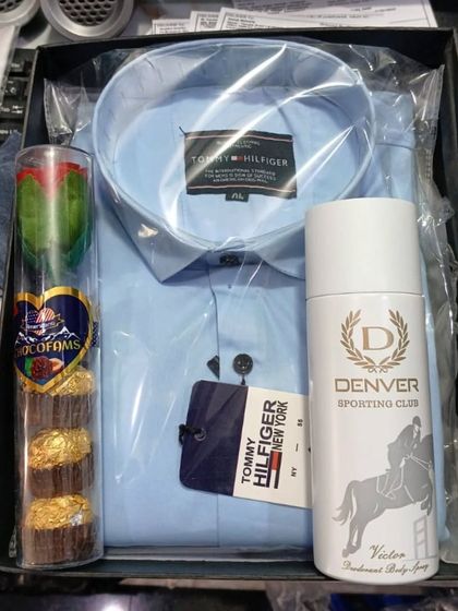A simple yet elegant hamper with a Tommy Hilfiger shirt, Denver deodorant, and a tube of chocolates.