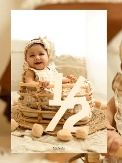 Another adorable half-birthday celebration. This baby girl smiles from her basket, holding a '1/2' sign.