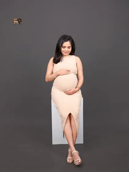 For those who love a clean and contemporary look, our modern studio sessions are ideal. This portrait features a simple bodycon dress and a neutral backdrop, putting all the focus on the beautiful baby bump and the mother's serene glow.