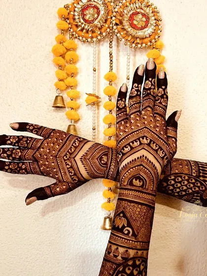 A beautiful shot of a traditional bridal design against a festive backdrop. The pattern features geometric shapes, elephant motifs, and intricate cuff details for a classic bridal look.