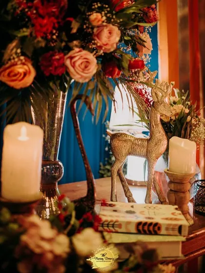 Another example of my detailed styling, where a golden deer figurine is paired with books and candles amidst a backdrop of vibrant red and blue florals.