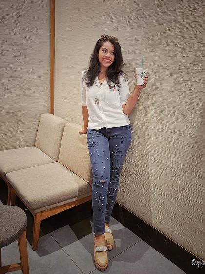 A simple and comfortable outfit with a white shirt and embellished jeans, perfect for a coffee run.