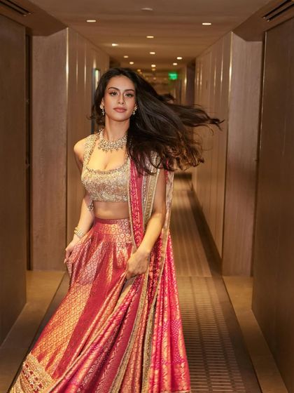 A candid, in-motion shot in a hotel corridor, capturing the beautiful movement and flow of the lehenga skirt.
