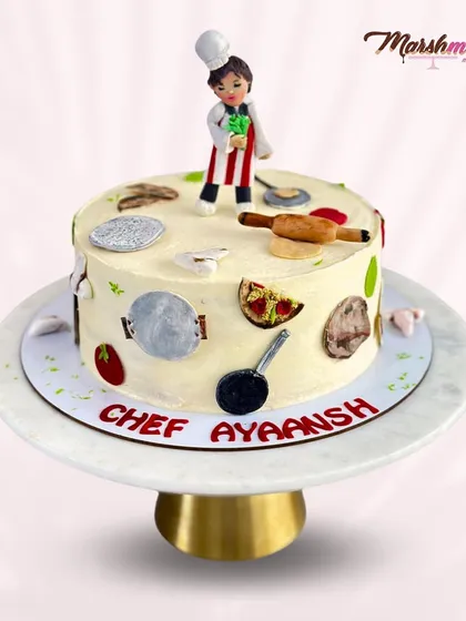 The full view of the cake for "Chef Ayaansh". It's a rich chocolate cake decorated with all his favourite kitchen tools, from a tawa and belan to a pizza slice, all edible.