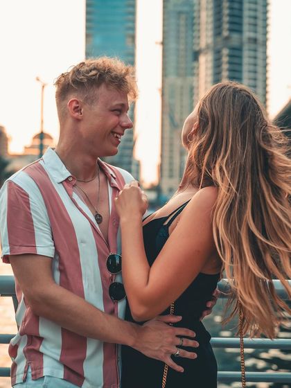 A candid interaction with the city lights and buildings creating a beautiful bokeh background. The focus is on the couple's connection, enhanced by the dynamic urban environment.