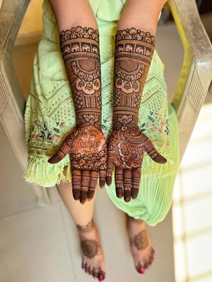 A complete view of the Radha Krishna bridal mehendi, including the feet. The cohesive design language ensures a harmonious and beautiful look for the bride.