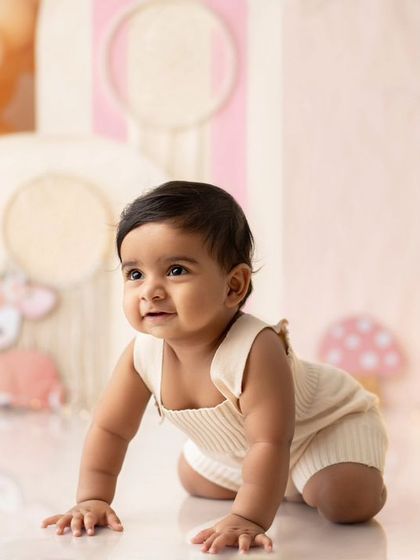 A happy baby crawling in the beautiful boho first birthday setup.