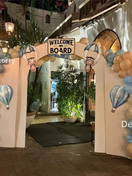 "Welcome on Board!" This entrance arch for an Aviator Bear theme immediately immerses guests in the world of adventure with hot air balloon details and a sky-blue color scheme.